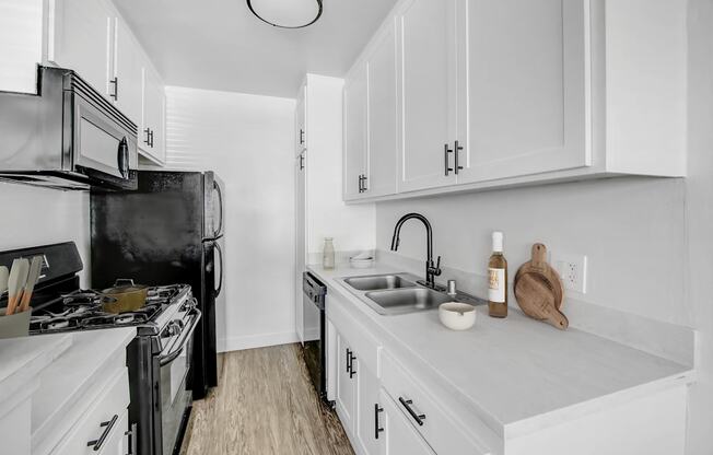 A kitchen with white cabinets and a black stove top oven.
