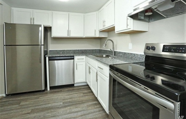 Kitchen with granite counters, stainless appliances, and white cabinets