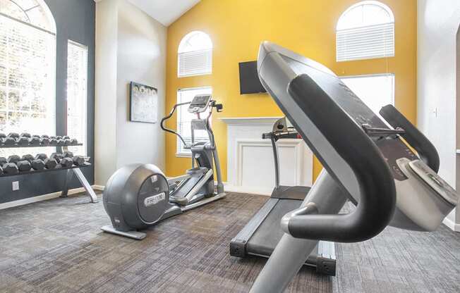 a gym with treadmills and exercise equipment at the district at highland village