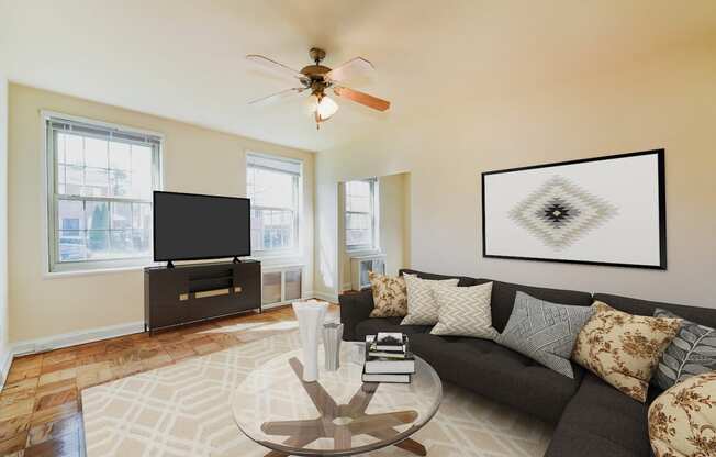 living area with sofa, large windows, tv, and hardwood flooring 1401 sheridan apartments in washington dc