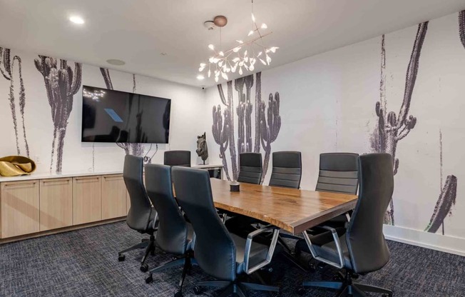 a conference room with a table and chairs and a tv on the wall