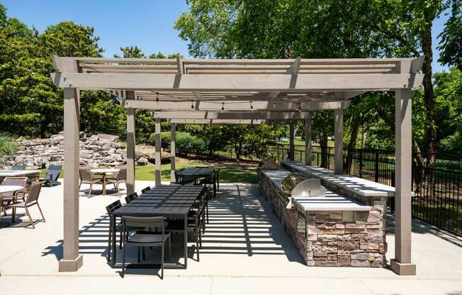 a patio with a picnic table and a barbecue grill