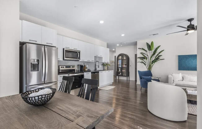 A modern kitchen with a dining area and a living room.