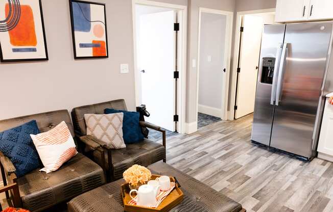 a living room with a couch and a coffee table and a refrigerator