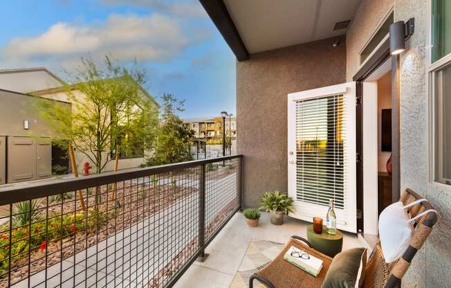 a balcony with a couch and a chair and a fence