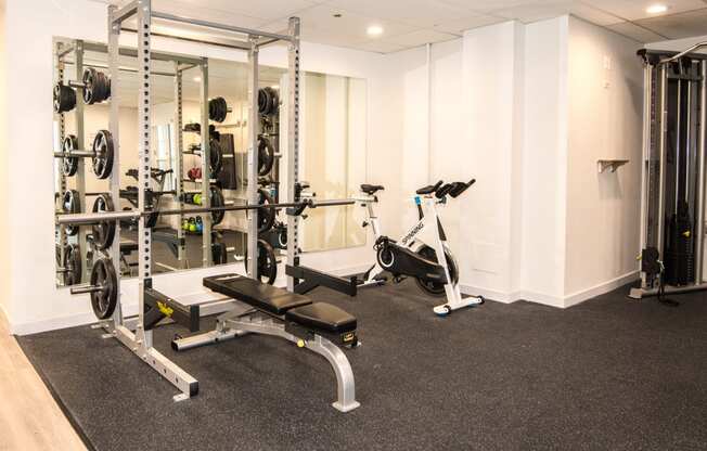 a gym with exercise equipment and weights on the floor