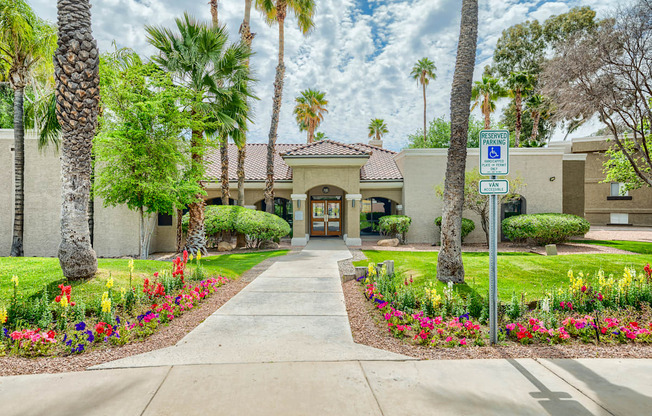 a sidewalk in front of a building with palm trees