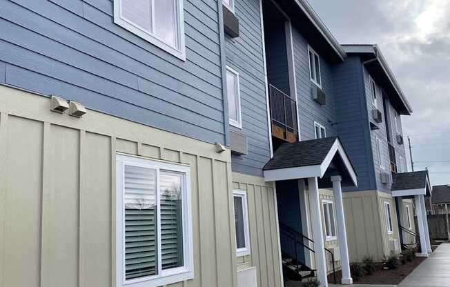 A row of houses with blue and beige siding.