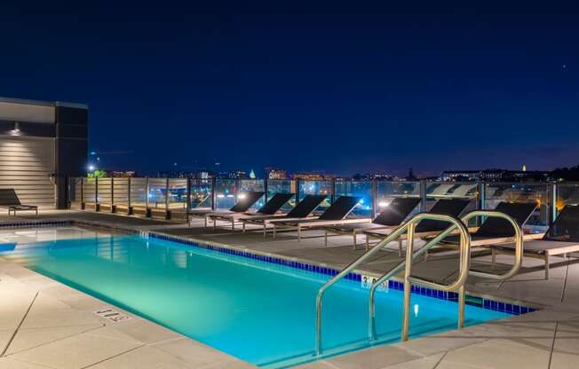 a swimming pool on the roof of a building at night