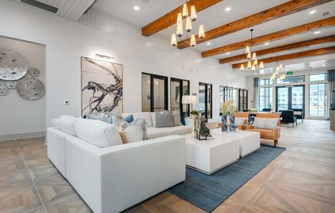 a living room with white couches and a rug