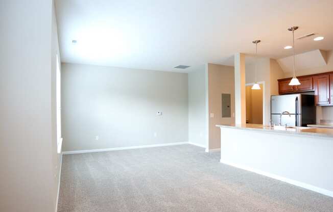 an empty living room and kitchen with a counter top