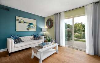 a living room with a blue accent wall and a sliding glass door leading to a patio
