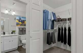 A white door is open to a bathroom with a toilet and sink.