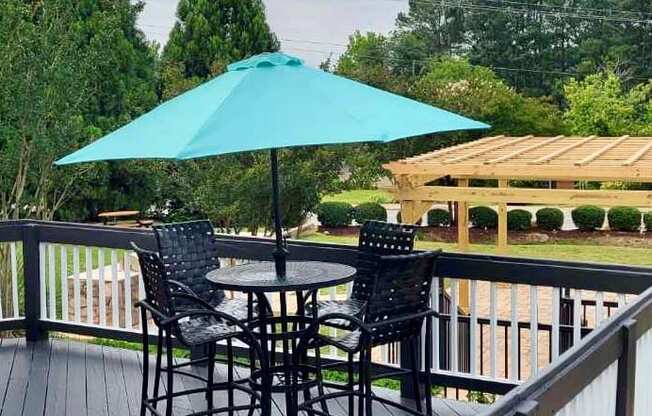 a table and chairs with an umbrella on a deck