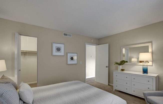 A bedroom with a bed, dresser, and mirror.