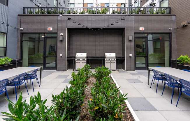 A modern building with a grey facade and a garden in front.