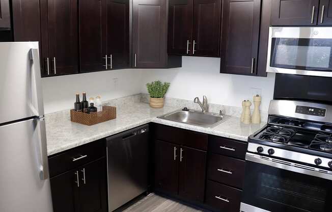 a kitchen with dark cabinets and white countertops