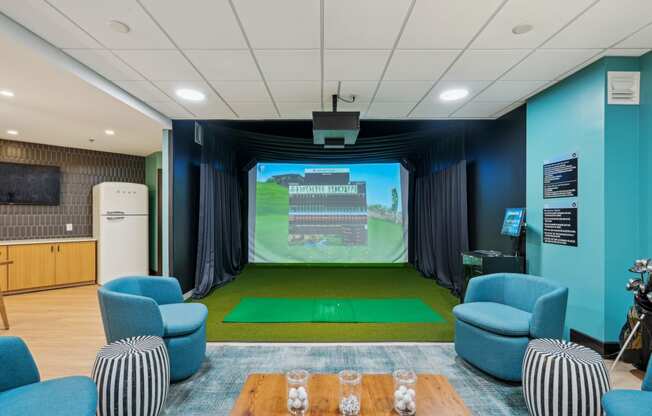 a room with a projector screen and chairs and a table