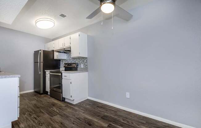 A kitchen with a refrigerator, oven, and cabinets.