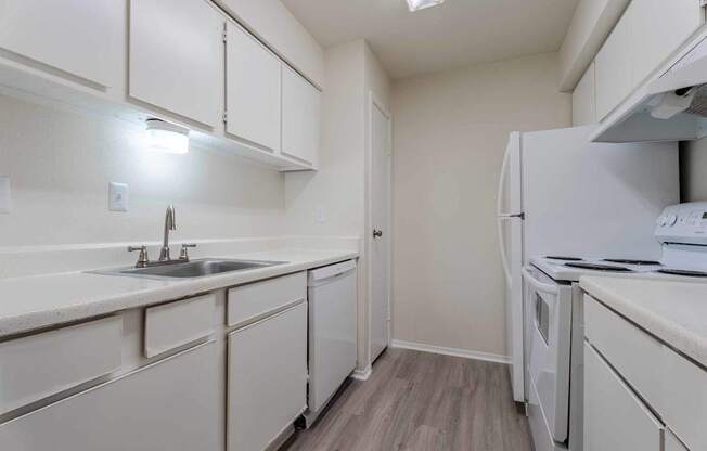 A kitchen with white cabinets and a white fridge.at 2400 Briarwest Apartments, Texas, 77077