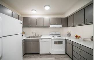 a kitchen with white appliances and gray cabinets at Summit, Pocatello Idaho