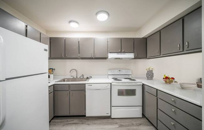 a kitchen with white appliances and gray cabinets at Summit, Pocatello Idaho