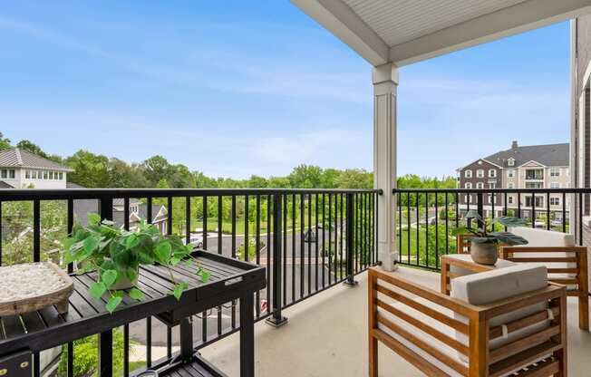 a balcony with a view of a yard and tables and chairs at Barclay Chase Apartment Homes, Marlton