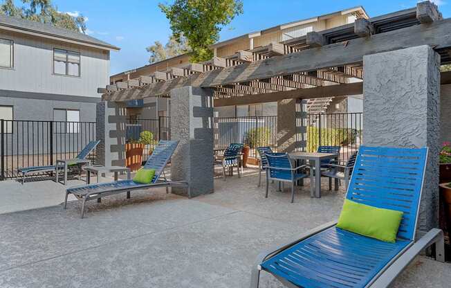 A blue bench with a green pillow is in the foreground of a patio area.