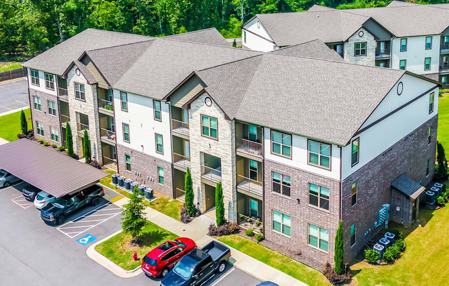 an aerial view of an apartment building with cars parked outside