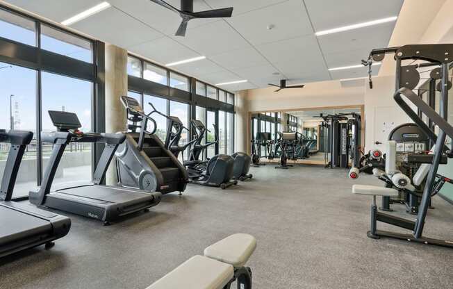 Studios In Wheat Ridge, CO - The Parallel - Fitness Center Equipped With Cardio Machines, Strength Training Machines, Full Body Mirror, And Floor To Ceiling Windows