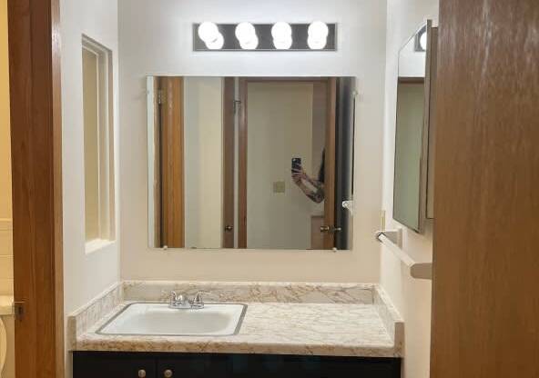 A bathroom with a sink and mirror.