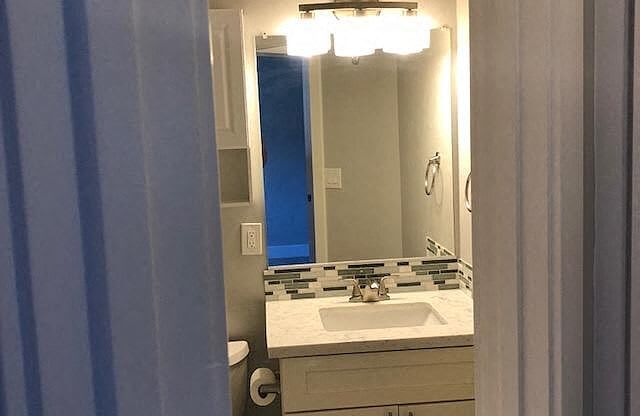 A bathroom with a sink and mirror.