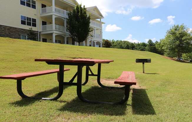 Community picnic area with table and charcoal grill at The Columns at Oakwood, Oakwood, GA
