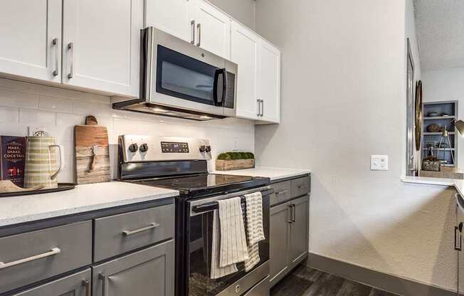 A kitchen with a black stove top oven and black cabinets.