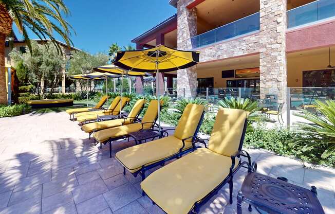 a row of yellow lounge chairs in front of a building