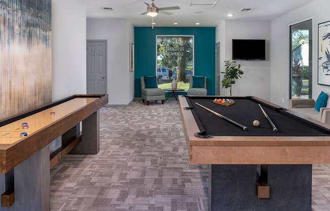 A room with a pool table and a tv.