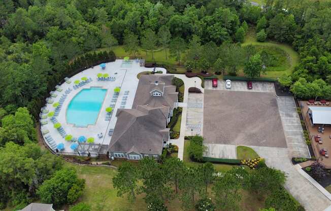 arial view of a pool and a house surrounded by trees