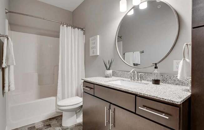 a bathroom with a sink and a toilet and a mirror. Circle Pines, MN Lexington Lofts