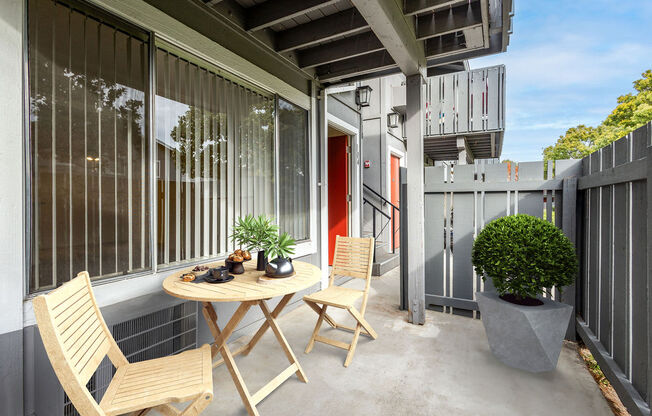 A small table with two chairs is on a patio.