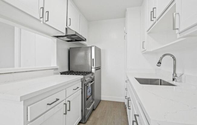 a kitchen with white cabinets and a stainless steel refrigerator