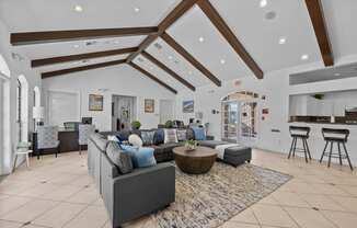 a living room with couches and a rug and a kitchen in the background