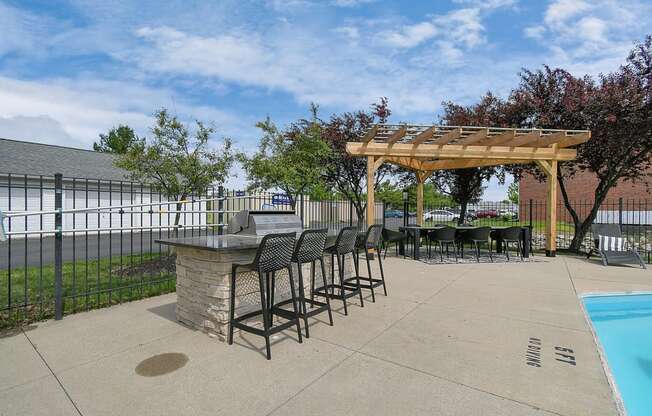 a patio with a barbecue grill and a pergola