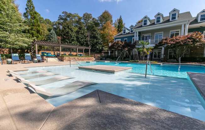 a large swimming pool with a house in the background