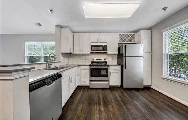 a kitchen with white cabinets and stainless steel appliances