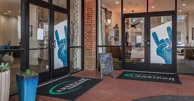 The entrance to a building with a brick wall and glass doors.