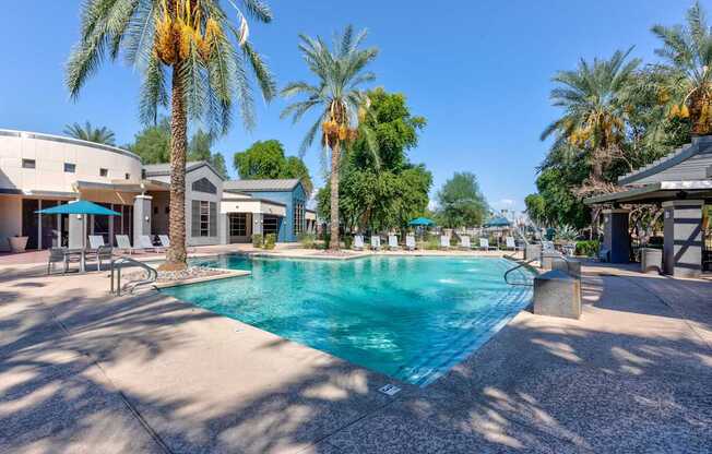 A swimming pool surrounded by palm trees and buildings.