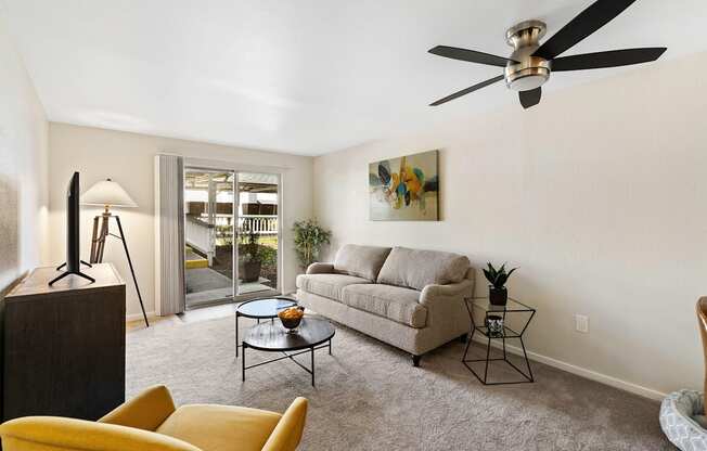 a living room with a couch coffee table and a ceiling fan