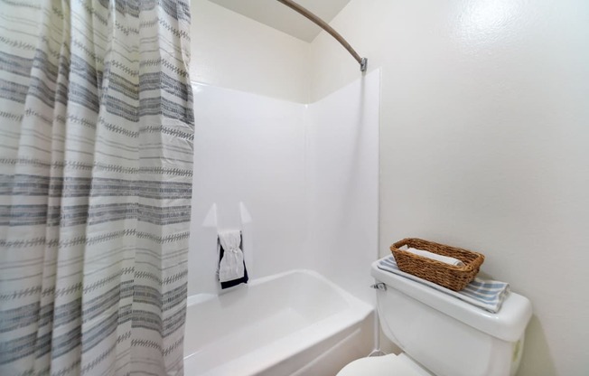 the bathroom has a shower curtain and a toilet and a sink