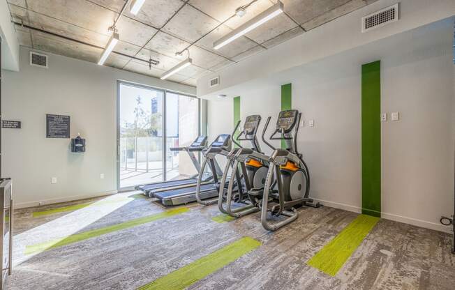 the gym at the building has cardio equipment and a window