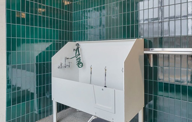 A white sink with a black drain board and a grey step.